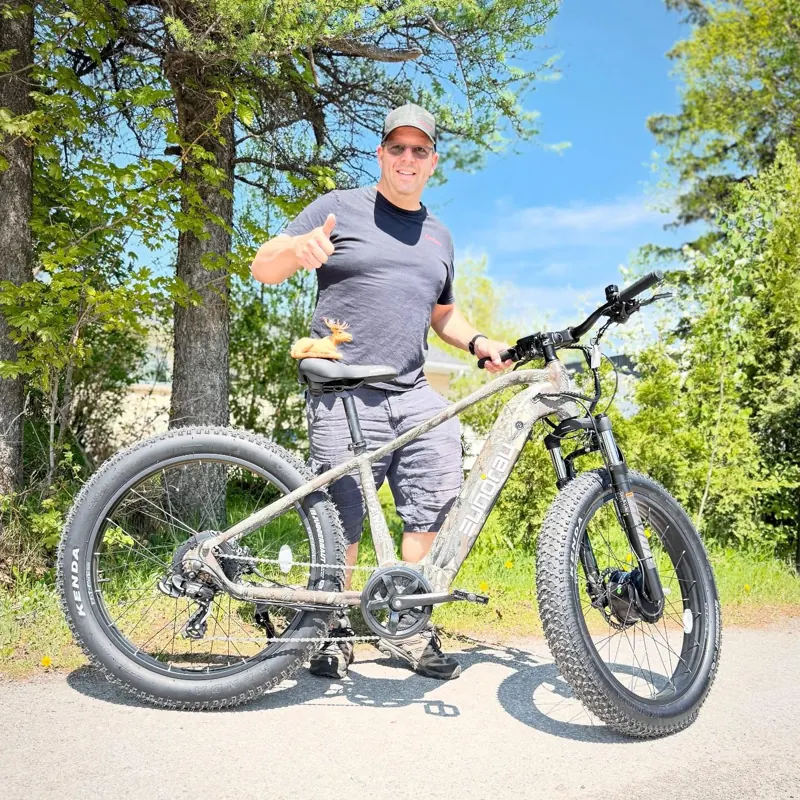 Rider giving a thumbs-up beside an EUNORAU bike outdoors
